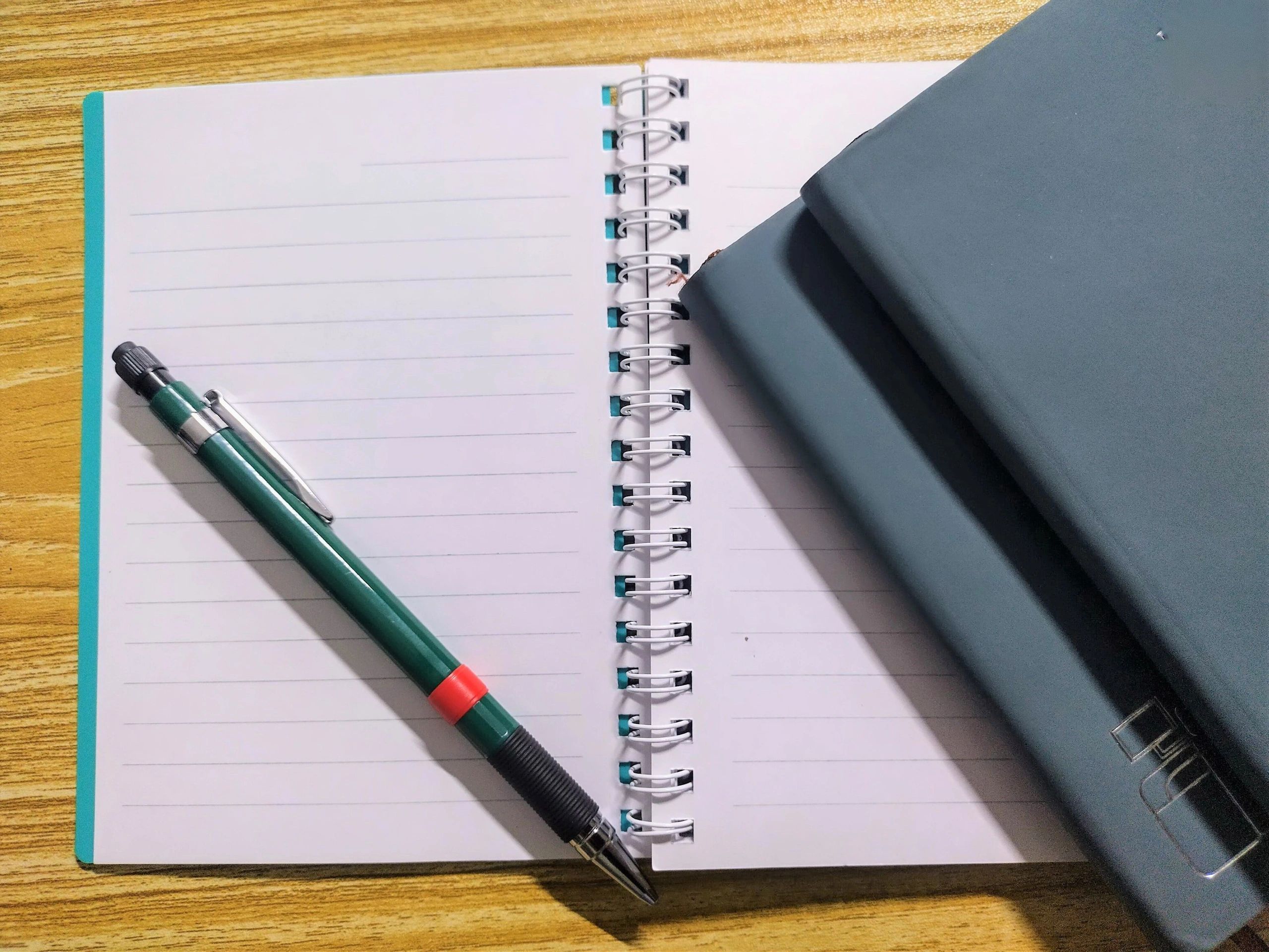 Open notebook with blank pages and pencil