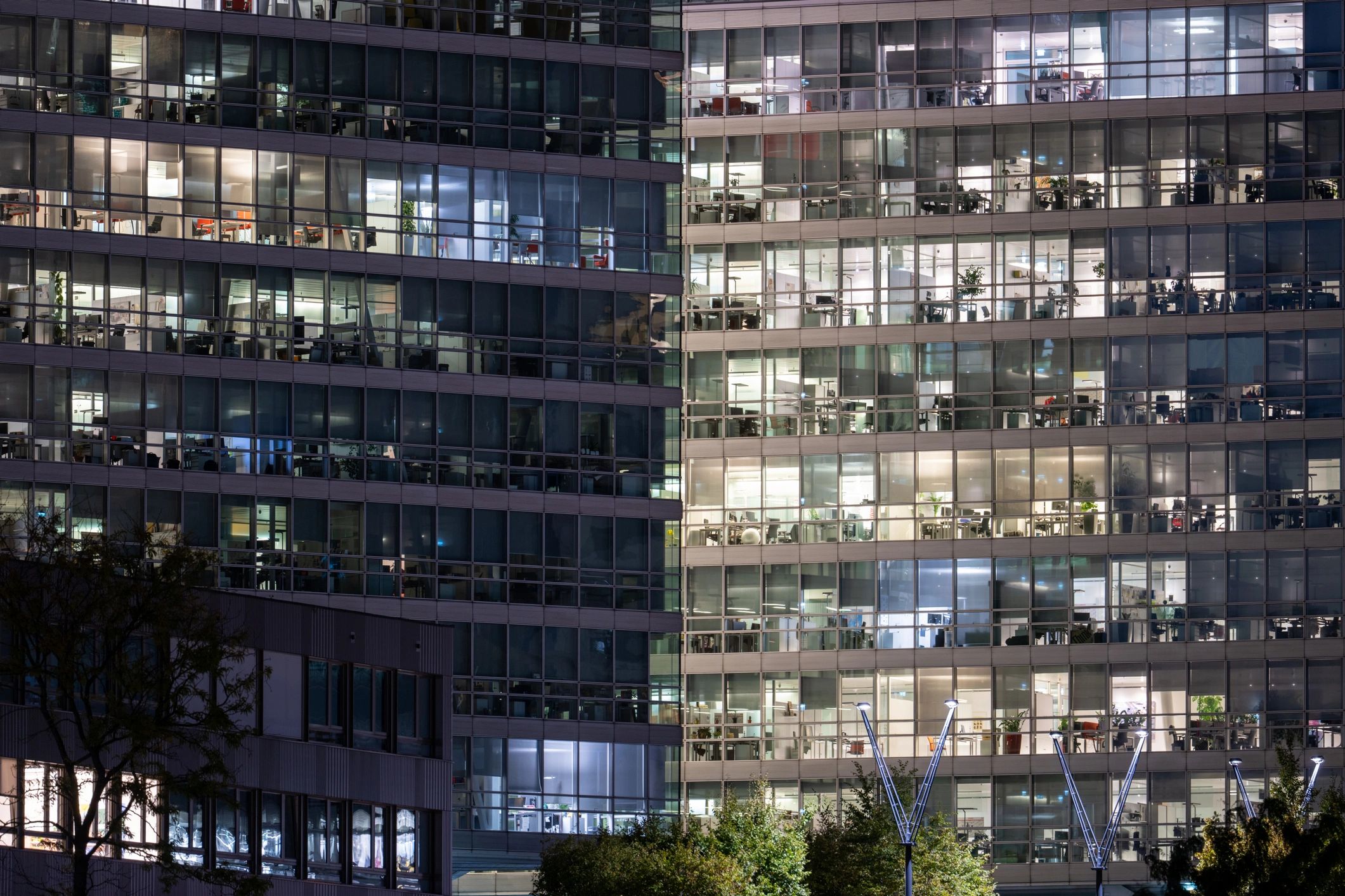 Modern glass building at night with lit windows