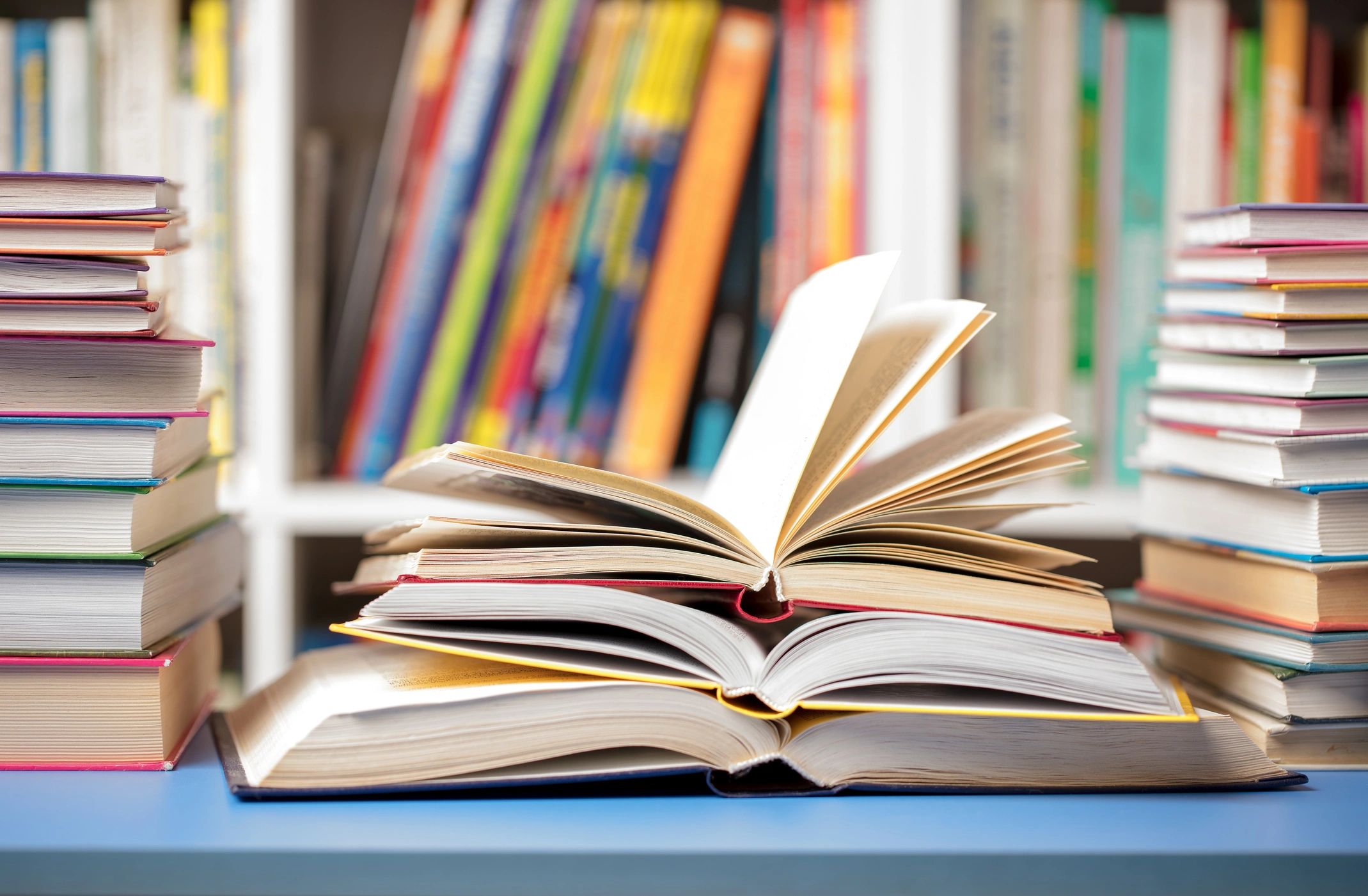 Books on a table with blurred library shelves in the background